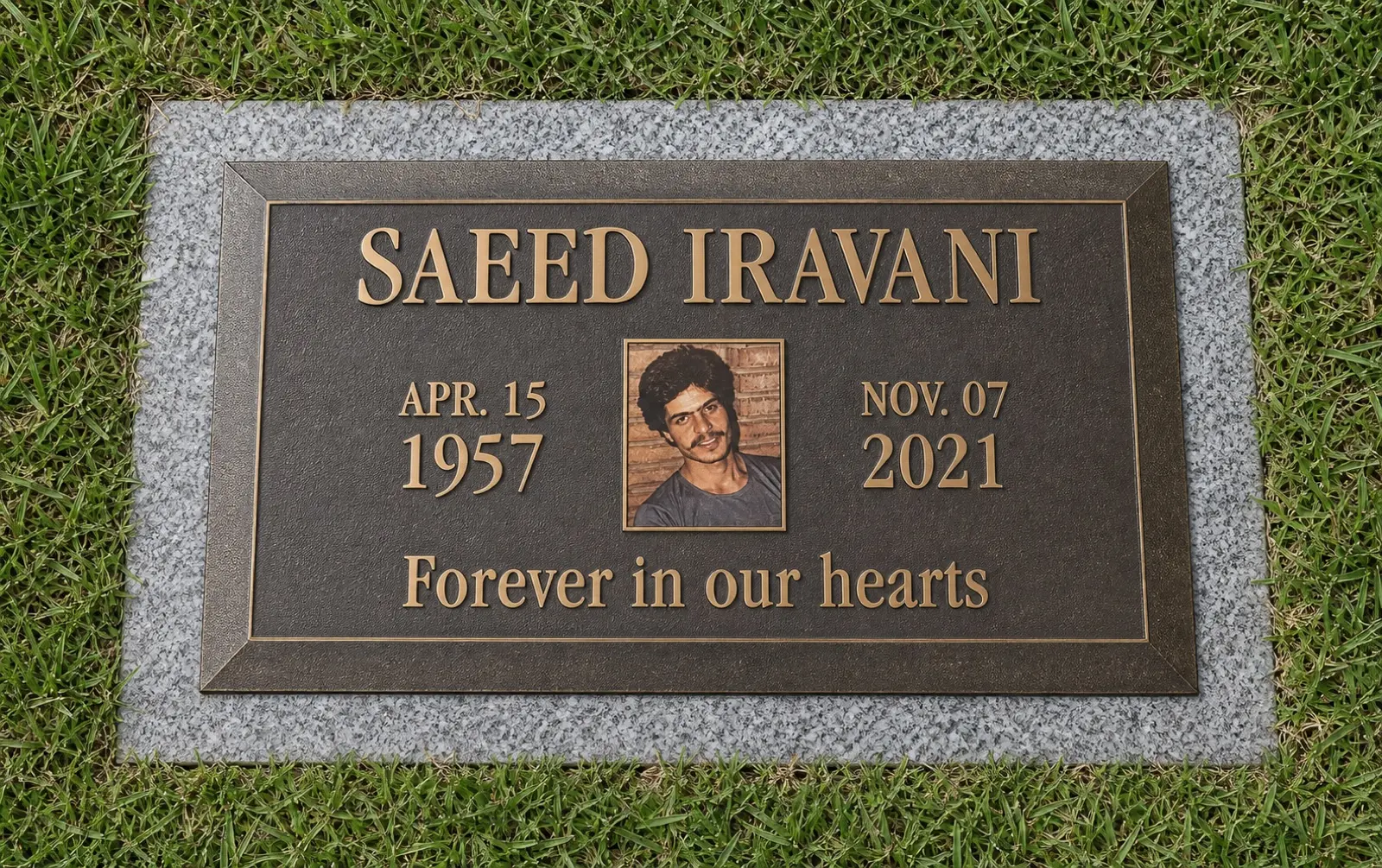 Realistic installed bronze memorial marker with a portrait and raised lettering on granite and grass