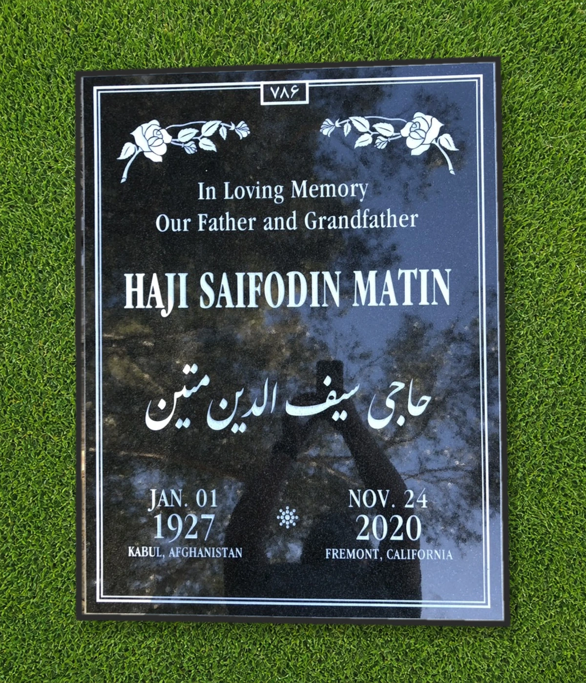 Black granite 39 by 30 inch half ledger with roses and multilingual lettering