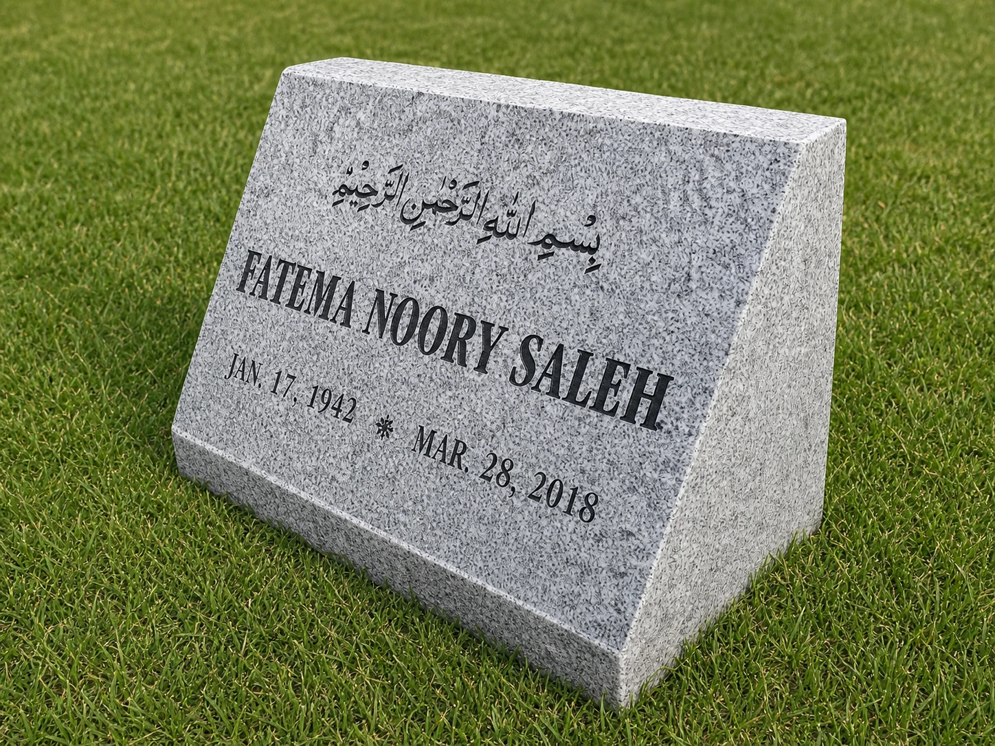 Light gray granite multilingual slanted marker displayed on grass